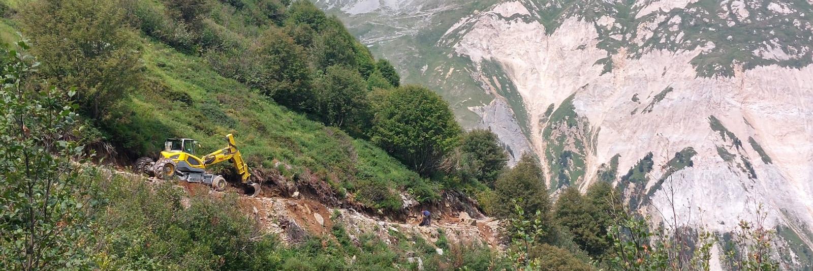 Engin de chantier arrangeant un sentier de montagne