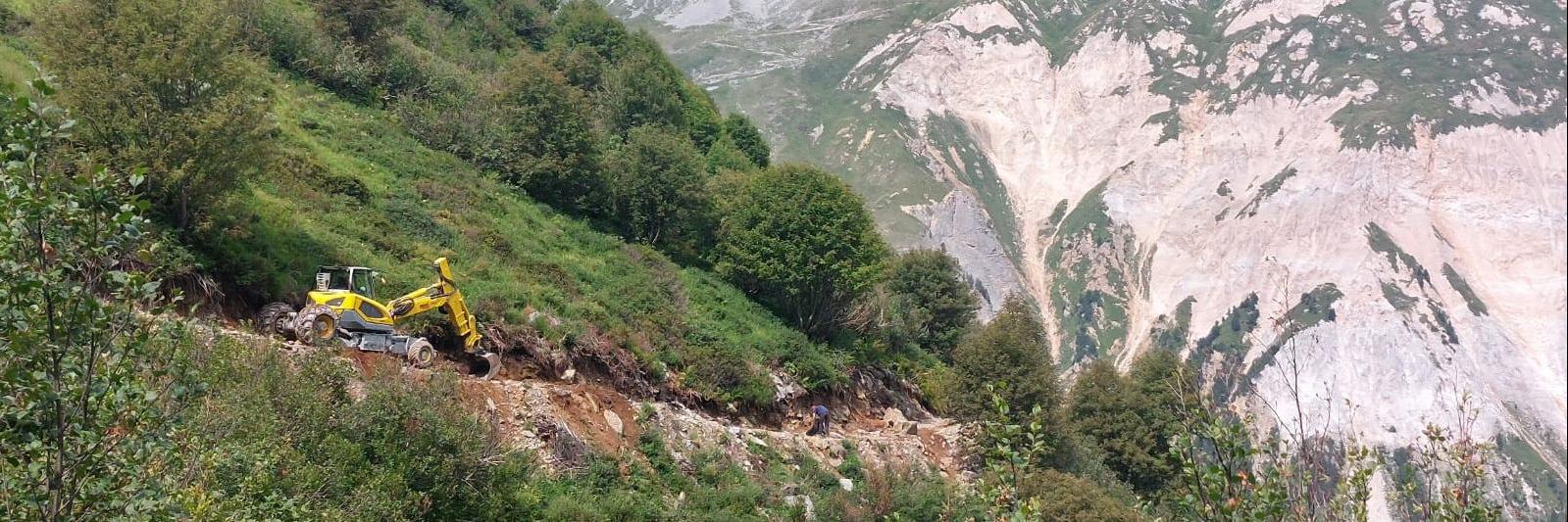 Travaux sur un chemin en montagne avec une pelleteuse