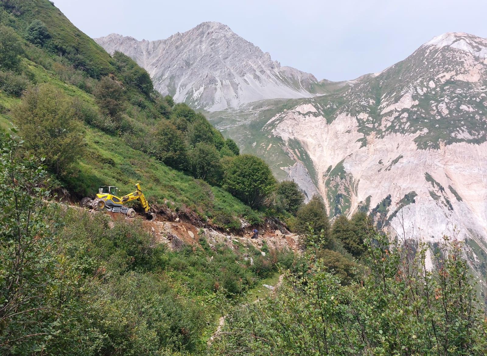 Engin de chantier arrangeant un sentier de montagne