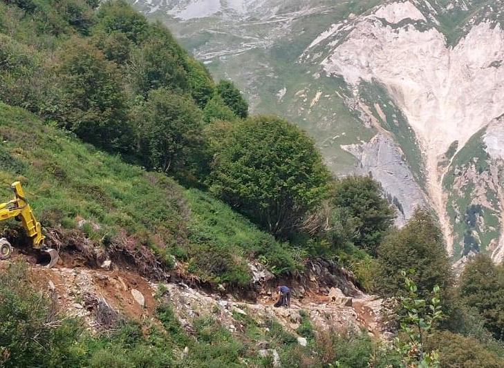 Travaux sur un chemin en montagne avec une pelleteuse